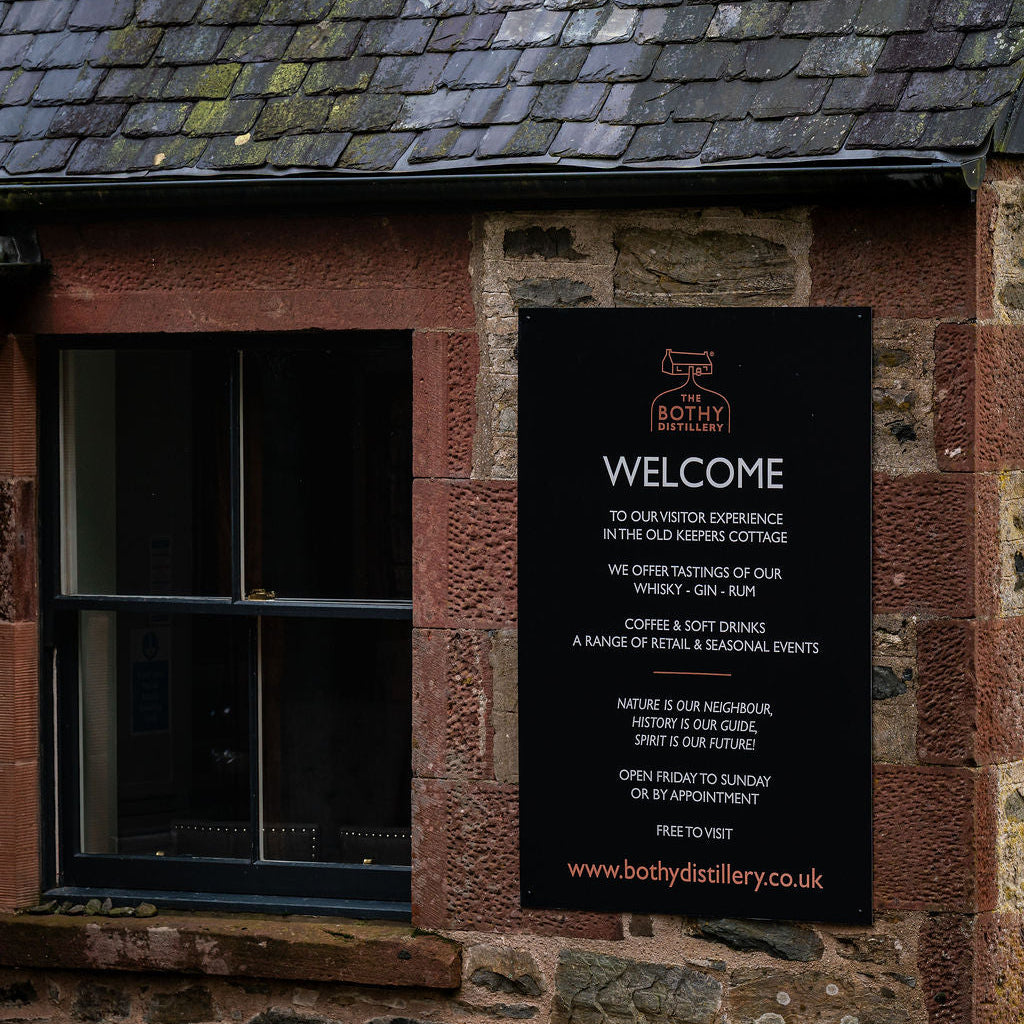 Welcome sign on a stone building with a window